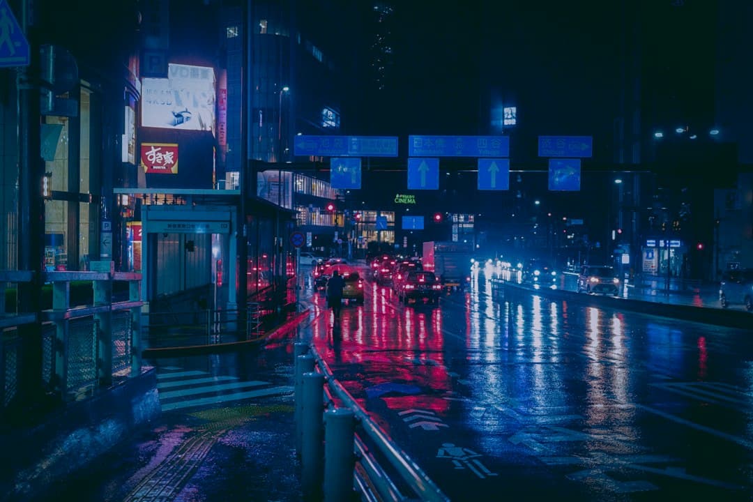 Eine Straße in der Stadt bei Nacht, beleuchtet von Ladenschildern und Laternen