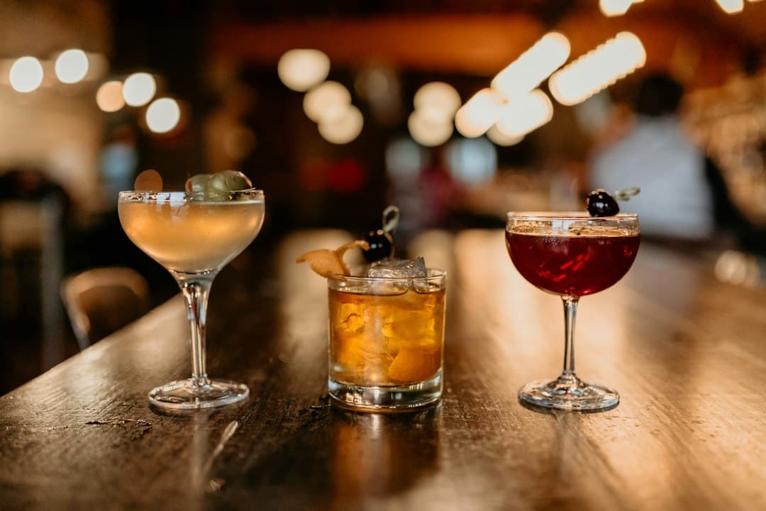 Zwei Cocktails auf einem schwach beleuchteten Bartresen