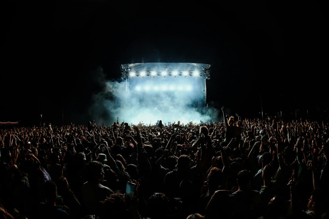 Große Festivalmenge bei Nacht vor einer hell beleuchteten Bühne im Nebel
